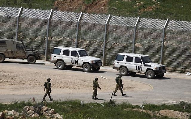Israeli soldiers walk past vehicles of the United Nations Disengagement Observer Force (UNDOF) near the town of Majdal Shams, on the Golan Heights, April 27, 2015. (AFP/Jalaa Marey) Israeli soldiers walk past vehicles of the United Nations Disengagement Observer Force (UNDOF) near the town of Majdal Shams, on the Golan Heights, April 27, 2015. (AFP/Jalaa Marey)