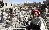 A Yemeni man sits on the rubble as people search for suvivors in houses destroyed by a Saudi-led air strike on a residential area in Yemen's capital, Sanaa, on May 1, 2015. (AFP/MOHAMMED HUWAIS)