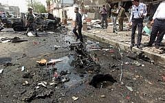 Iraqi security forces inspect the scene of a car-bomb blast targeting Shiite pilgrims on an annual march to a Baghdad shrine on May 9, 2015. (AFP/Ahmad al-Rubaye)