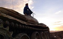 An armed Yemeni tribesman from the Popular Resistance Committees supporting forces loyal to Yemen's Saudi-backed fugitive President Abedrabbo Mansour Hadi sits on a tank at sunset in Marib province east of the capital, Sanaa, on May 9, 2015. (Photo credit: AFP)