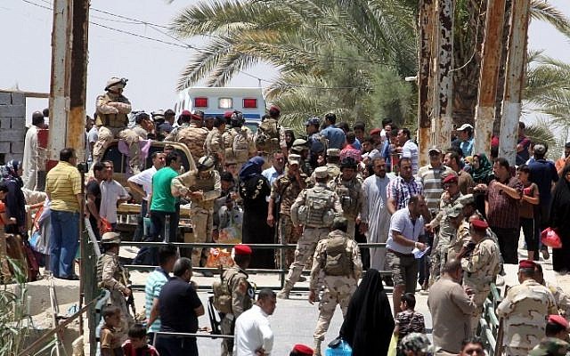 Iraqi security forces stand guard as residents from the city of Ramadi, who fled their homes to escape an advance by Islamic State group forces, wait to cross Bzeibez bridge, May 16, 2015 (AFP/ SABAH ARAR) Iraqi security forces stand guard as residents from the city of Ramadi, who fled their homes to escape an advance by Islamic State group forces, wait to cross Bzeibez bridge, May 16, 2015 (AFP/ SABAH ARAR)