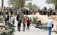 Residents from the city of Ramadi, who fled their homes on May 16, 2015 as Islamic State (IS) group militants tightened their siege on the last government positions in the capital of Anbar province, wait to cross Bzeibez bridge on the southwestern frontier of Baghdad with Anbar province. IS group jihadists took control of all the other routes connecting the province with the Iraqi capital. (AFP/ SABAH ARAR)