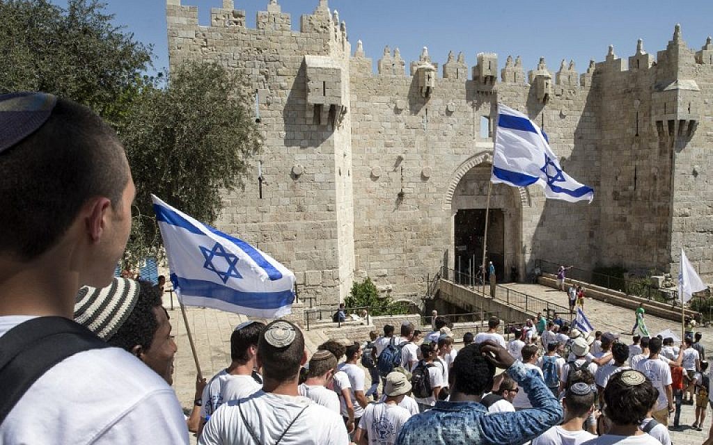 Israeli youth hold their national flag as they take part in the "flag march" through Damascus Gate in Jerusalem's Old City during celebrations for Jerusalem Day on May 17, 2015. (AFP Photo/Jack Guez)