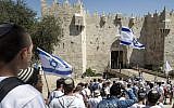 Israeli youth hold their national flag as they take part in the "flag march" through Damascus Gate in Jerusalem's Old City during celebrations for Jerusalem Day on May 17, 2015. (AFP Photo/Jack Guez)