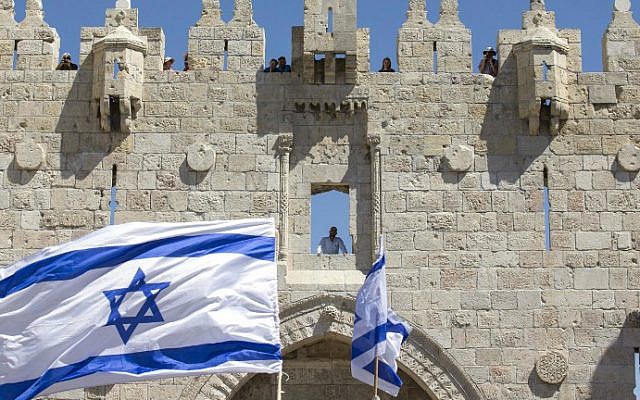 Israeli youth wave the nation's flag in the "flag march" through Damascus Gate in Jerusalem's Old City during celebrations for Jerusalem Day on May 17, 2015. (AFP Photo/Jack Guez)