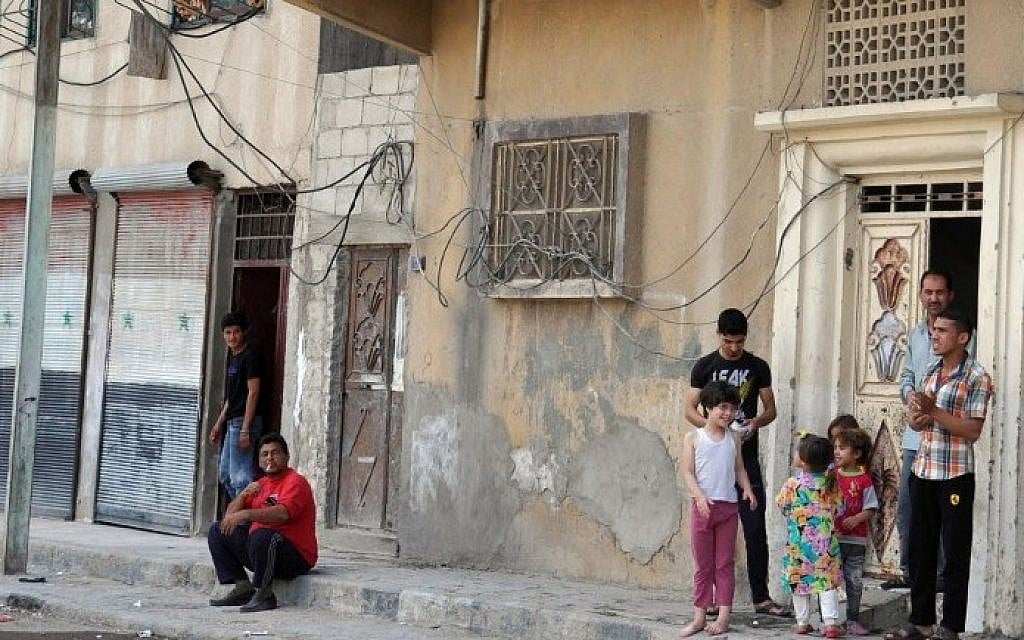 Syrians stand and look out on the street of the ancient Syrian city of Palmyra on May 18, 2015, a day after Islamic State (IS) group jihadists fired rockets into the city, killing several people.  (AFP PHOTO /STR)