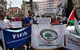 Palestinians hold banners as they demonstrate in the center of Ramallah, demanding the suspension of Israel from FIFA, May 20, 2015. (AFP/Abbas Momani)