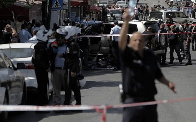 Israeli police cordon off the site of an attack in East Jerusalem after two Israeli policemen were injured when they were hit by a car driven by a Palestinian, who was then shot dead, May 20, 2015. (AFP/AHMAD GHARABLI) 