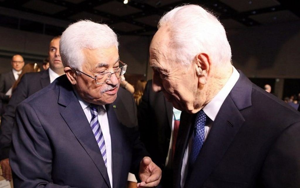 Former president Shimon Peres (right) shakes hands with Palestinian Authority President Mahmoud Abbas (left) on the opening day of the World Economic Forum on the Middle East and North Africa 2015, taking place in the Dead Sea resort of Shuneh, Jordan, on May 22, 2015. (AFP/Khalil Mazraawi)