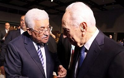 Former president Shimon Peres (right) shakes hands with Palestinian Authority President Mahmoud Abbas (left) on the opening day of the World Economic Forum on the Middle East and North Africa 2015, taking place in the Dead Sea resort of Shuneh, Jordan, on May 22, 2015. (AFP/Khalil Mazraawi)