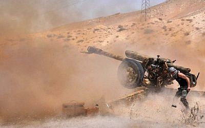 A Syrian army soldier fires artillery shells towards Islamic State (IS) jihadists in northeastern Palmyra on May 17, 2015. (AFP/STR)