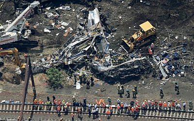 Investigators and first responders work near the wreckage of Amtrak Northeast Regional Train 188, from Washington to New York, that derailed yesterday May 13, 2015 in north Philadelphia, Pennsylvania. (photo credit: Win McNamee/Getty Images/AFP)