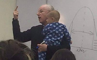 Prof. Syndey Engelberg holds baby during his Hebrew University class. (Sarit Fishbaine/Facebook)