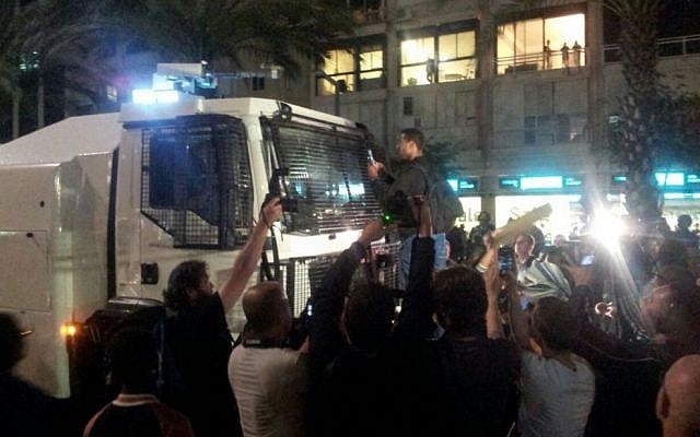 Protesters surround a water cannon truck in Tel Aviv. May 3, 2015 (photo credit: Judah Ari Gross/Times of Israel) Protesters surround a water cannon truck in Tel Aviv. May 3, 2015 (photo credit: Judah Ari Gross/Times of Israel)