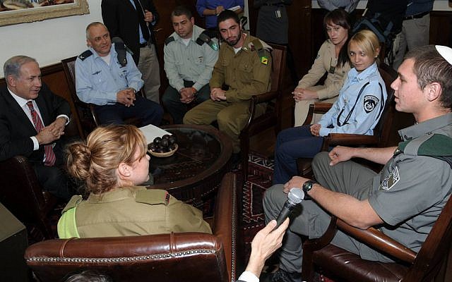 Benjamin Netanyahu, left, and then-IDF Chief Education Officer Brig. Gen. Eli Schermeister, second left, along with an education corps officer, back to camera, and potential converts on December 15, 2010 (Amos Ben-Gershom/ GPO/ courtesy)