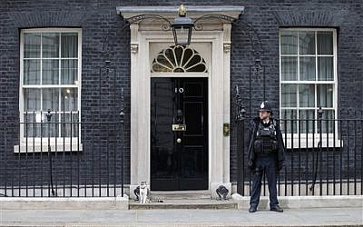 A police officer and Larry the Downing Street cat outside 10 Downing Street, London, Saturday, May 9, 2015 (AP Photo/Tim Ireland)