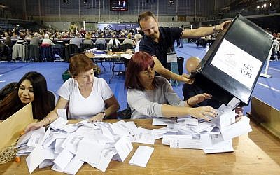 The first votes arrive at the general election count for the Glasgow constituencies at the Emirates Arena in Glasgow, Scotland, May 7, 2015. (photo credit: Danny Lawson/PA via AP)