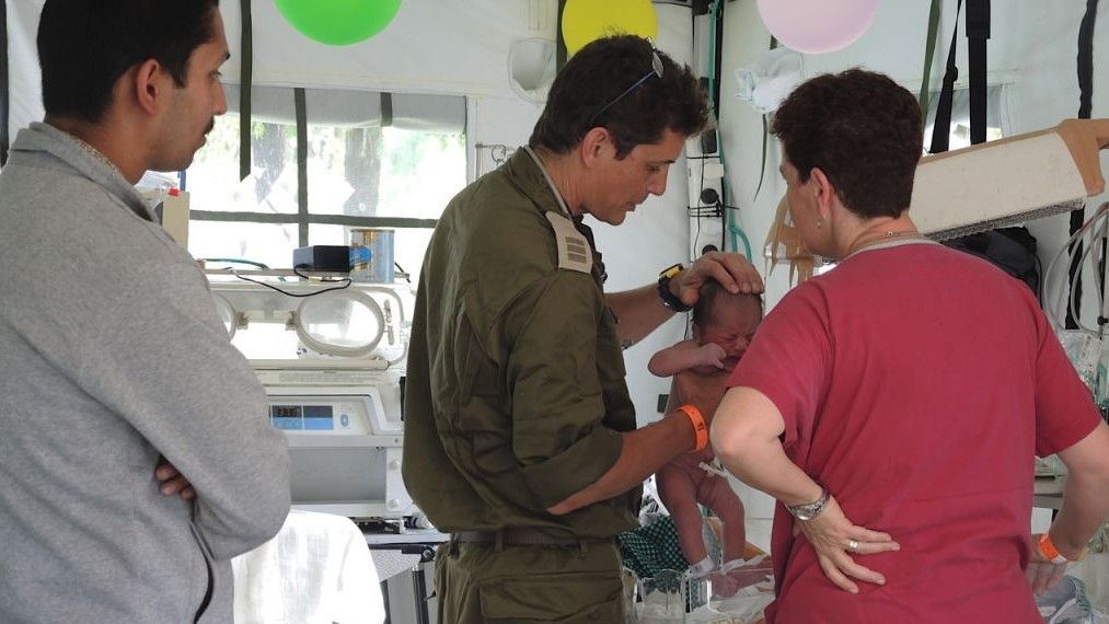 Doctors examine baby Chand just a few hours after her birth, as father Harendra Chand looks on, May 1, 2015 (Photo credit: Melanie Lidman). Doctors examine baby Chand just a few hours after her birth, as father Harendra Chand looks on, May 1, 2015 (Photo credit: Melanie Lidman).
