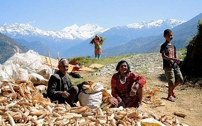 A family tries to salvage some of their food rescued from a collapsed home in the remote village of Tar, in the Sindhupalchuk district of Nepal, on May 1, 2015. (photo credit: Melanie Lidman/Times of Israel)
