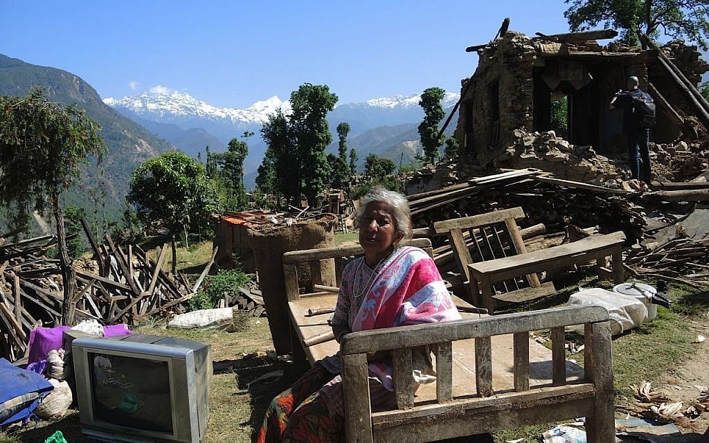 A woman sits with the salvaged items from her home in the village of Topani, Nepal. The villages had had electricity from a hydroelectric dam in the river, but it will likely be months before electricity can be restored to this area. May 2015. (photo credit: Melanie Lidman/Times of Israel)