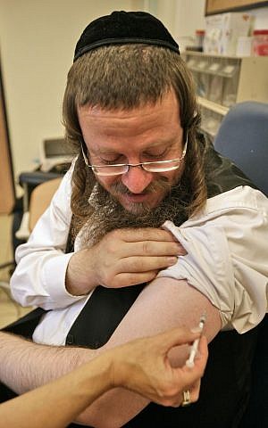 An ultra-Orthodox man holding a swine flu vaccine in Geula neighborhood in Jerusalem on Nov 09, 2009. ( Abir Sultan/Flash 90)