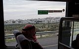 A Palestinian man rides the bus near the city of Bethlehem, December 18, 2014 (Miriam Alster/Flash90)