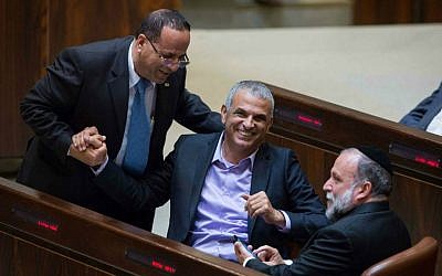 Kulanu party leader Moshe Kahlon (C) laughs with Likud's Ayoub Kara and Shas's Yitzhak Cohen in the Knesset plenum, May 4, 2015. (Miriam Alster/Flash90)