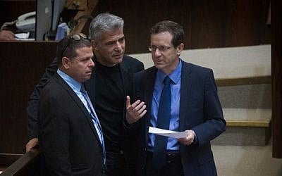 Zionist Union leader Isaac Herzog speaks with Yesh Atid party leader Yair Lapid and Zionist Union MK Eitan Cabel during a plenum session on expanding the number of ministers in the new cabinet, on May 11, 2015. (Photo credit: Miriam Alster/Flash90)