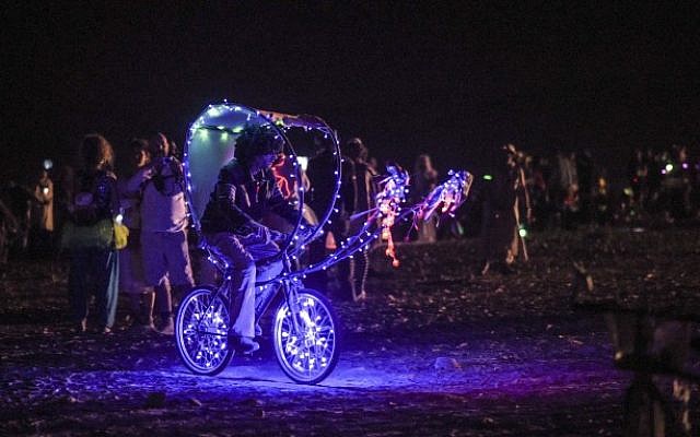 An art bike rides through the 67 art installations scattered across the Midburn Festival from May 20-24.  (Ben Kelmer/Flash90)