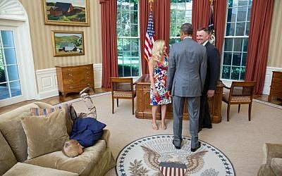 A departing United States Secret Service agent and his wife meet with President Obama as their son plants himself into the sofa in 2014. (Official White House photo by Lawrence Jackson)