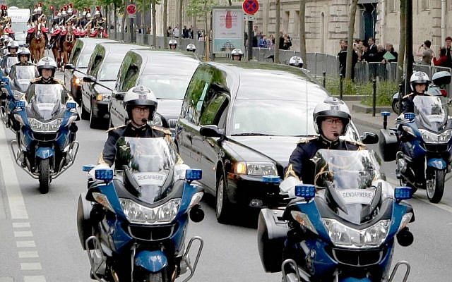 The coffins of four World War II resistance fighters are symbolically escorted through the streets of Paris for a ceremony at the Sorbonne University, Tuesday, May 26, 2015. (AP Photo/Jacques Brinon)