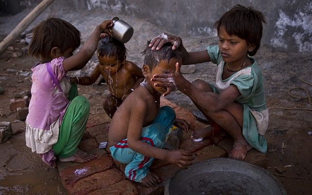 Two young girls bathe their siblings by a public tap on a hot summer day at Badshahpur, on the outskirts of New Delhi, India, Wednesday, May 27, 2015. Delhi recorded a maximum temperature of 42 degrees Celsius on Wednesday. In southern India, hundreds of people have died since the middle of April as soaring summer temperatures scorch the country, officials said Tuesday. (AP Photo/Saurabh Das) Two young girls bathe their siblings by a public tap on a hot summer day at Badshahpur, on the outskirts of New Delhi, India, Wednesday, May 27, 2015. Delhi recorded a maximum temperature of 42 degrees Celsius on Wednesday. In southern India, hundreds of people have died since the middle of April as soaring summer temperatures scorch the country, officials said Tuesday. (AP Photo/Saurabh Das)
