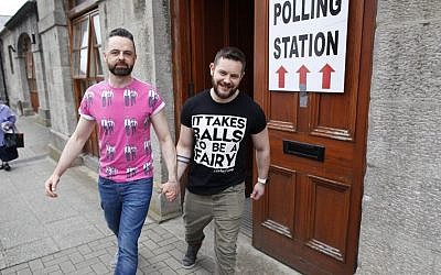 Partners Adrian, center left and Shane, leave a polling station after casting their vote in Drogheda, Ireland, Friday, May 22, 2015. (AP/Peter Morrison)