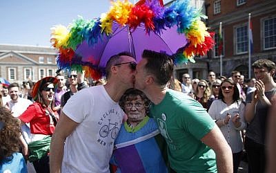 Two men kiss as first results start to filter through in the referendum, Dublin, Ireland, Saturday, May 23, 2015. Ireland voted resoundingly to legalize gay marriage. (AP Photo/Peter Morrison)