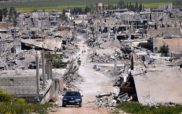 A car passes through Kobani, north Syria on April 18, 2015. The area was destroyed during the battle between the US-backed Kurdish forces and the Islamic State fighters. (Mehmet Shakir/AP)
