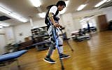 Yuichi Imahata walks using a robotic exoskeleton called ReWalk at Kanagawa Rehabilitation Center in Atgugi, Japan on April 17, 2015. Imahata, 31, has been using a wheelchair to get around for seven years after a serious spinal-cord injury suffered in an accidental fall while working for a transport company.  (Photo credit: Shuji Kajiyama/AP)