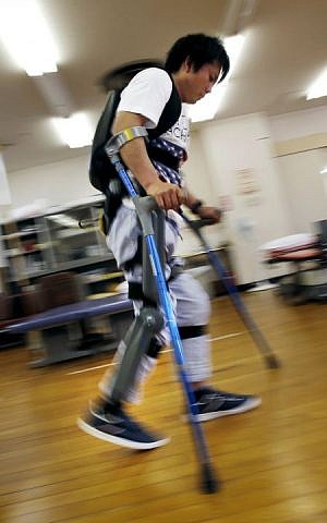 Yuichi Imahata walks using a robotic exoskeleton called ReWalk at Kanagawa Rehabilitation Center in Atgugi, Japan on April 17, 2015. Imahata, 31, has been using a wheelchair to get around for seven years after a serious spinal-cord injury suffered in an accidental fall while working for a transport company.  (Photo credit: Shuji Kajiyama/AP)