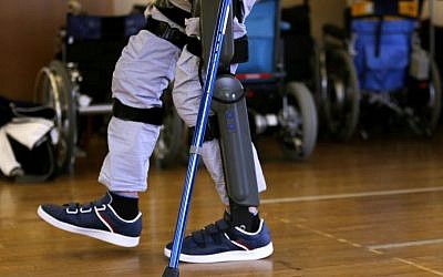 Yuichi Imahata walks using a robotic exoskeleton called ReWalk at Kanagawa Rehabilitation Center in Atgugi, Japan on April 17, 2015. Imahata, 31, has been using a wheelchair to get around for seven years after a serious spinal-cord injury suffered in an accidental fall while working for a transport company.  (Photo credit: Shuji Kajiyama/AP)