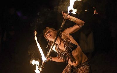 A Midburn participant twirls a flaming baton at the second annual festival modeled after America's Burning Man on May 24, 2015. (Ben Kelmer/Flash90)