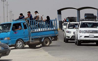 In this Monday, May 18, 2015 photo, civilians fleeing their hometown of Ramadi, Iraq, pull over their truck at a police checkpoint as they drive through Habaniyah town, 80 kilometers (50 miles) west of Baghdad. (AP)