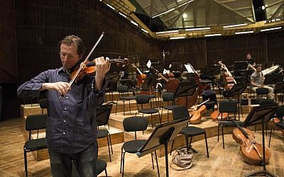 David Radzynski an American-Israeli concertmaster of the Israel Philharmonic Orchestra, plays during a rehearsal in Tel Aviv on May 3, 2015. Radzynski is still getting used to his first job out of college as the new concertmaster of the Israel Philharmonic Orchestra - and to being one of the youngest violinists to lead a major world orchestra today. (photo credit: AP Photo/Tsafrir Abayov)