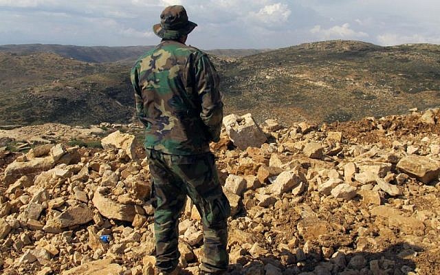 A Hezbollah fighter looks toward Syria while standing in the fields of the Lebanese border village of Brital, Lebanon, May 9, 2015. (photo credit: AP/Bassem Mroue) A Hezbollah fighter looks toward Syria while standing in the fields of the Lebanese border village of Brital, Lebanon, May 9, 2015. (photo credit: AP/Bassem Mroue)