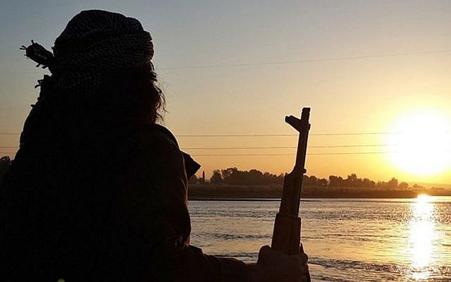 ILLUSTRATIVE: An Islamic State fighter holds his AK-47 machine gun as he stands guard on the bank of the Euphrates River in Raqqa, Syria. (Militant website via AP) ILLUSTRATIVE: An Islamic State fighter holds his AK-47 machine gun as he stands guard on the bank of the Euphrates River in Raqqa, Syria. (Militant website via AP)