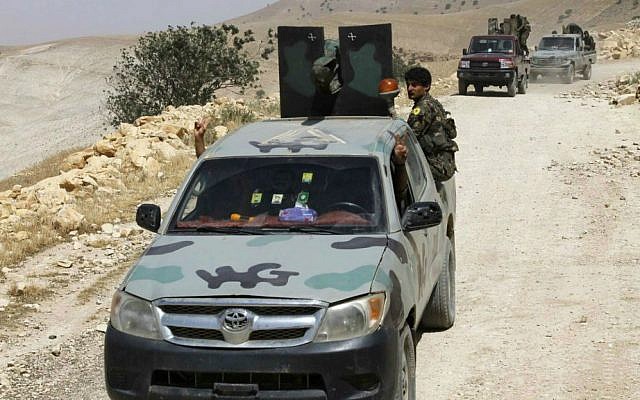In this photo released on May 20, 2015, provided by the Kurdish fighters of the People’s Protection Units (YPG), which has been authenticated based on its contents and other AP reporting, Kurdish fighters of the YPG stand on their vehicles on their way to battle against the Islamic State, near Kezwan mountain, northeast Syria. (The Kurdish fighters of the People’s Protection Units via AP)