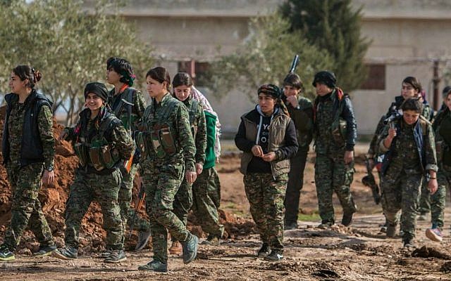 In this photo released on May 16, 2015, provided by the Kurdish fighters of the People's Protection Units (YPG), which has been authenticated based on its contents and other AP reporting, Kurdish female fighters of the YPG carry their weapons as they walk at the front line of Kery Sabee village, northeast Syria. (The Kurdish fighters of the People's Protection Units via AP)