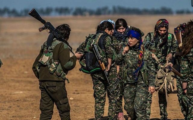 In this photo released on May 24, 2015, Kurdish female fighters of the YPG carry their weapons as they prepare for a battle against Islamic State fighters near the village of Mabrouka, northeast Syria. (The Kurdish fighters of the People's Protection Units via AP)