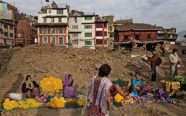 Nepalese flower vendors wait for customers at the Basantapur Durbar Square, damaged in the April 25 earthquake in Kathmandu, Nepal, Tuesday, May 5, 2015. (photo credit: AP/Bernat Amangue)
