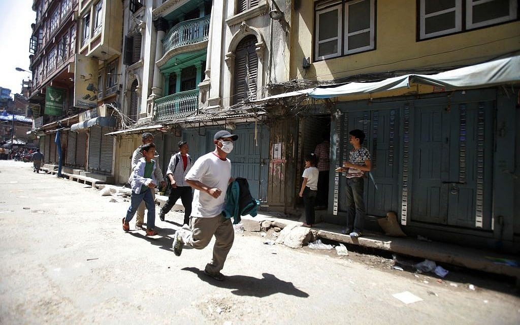 A Nepalese man runs to safety after a second earthquake hit Nepal in Kathmandu, Nepal, Tuesday, May 12, 2015 (AP Photo/Bikram Rai)