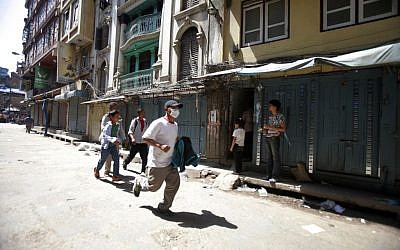 A Nepalese man runs to safety after a second earthquake hit Nepal in Kathmandu, Nepal, Tuesday, May 12, 2015 (AP Photo/Bikram Rai)