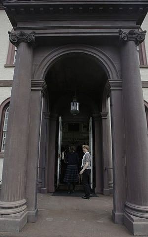In this Thursday, May 28, 2015 photo, a guide stands at the doors of Touro Synagogue, the nation's oldest, in Newport, Rhode Island. (AP/Stephan Savoia)